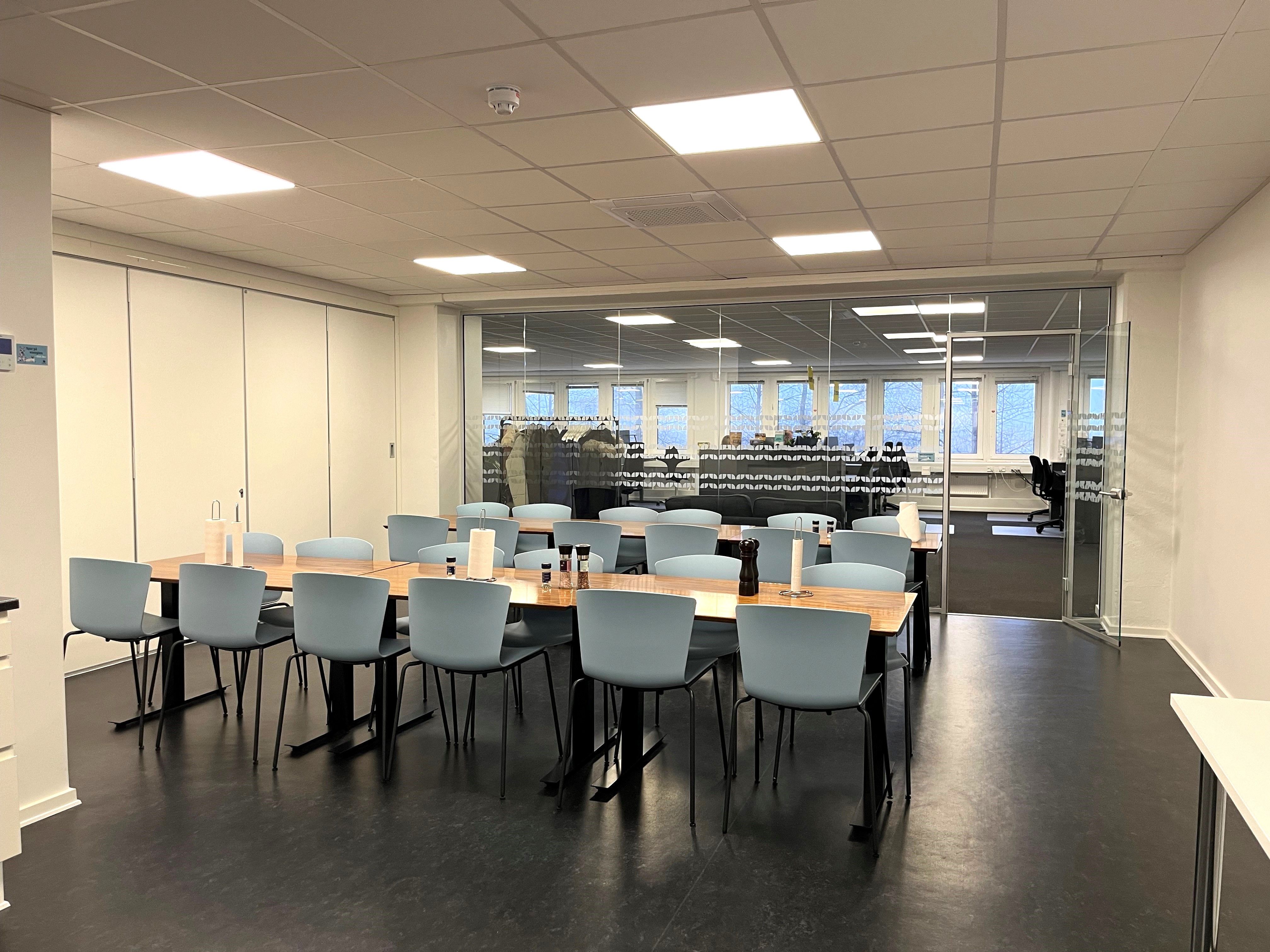 Kontorlokaler med lyse lofter og moderne møbler, gulv og lyse træborde og stole