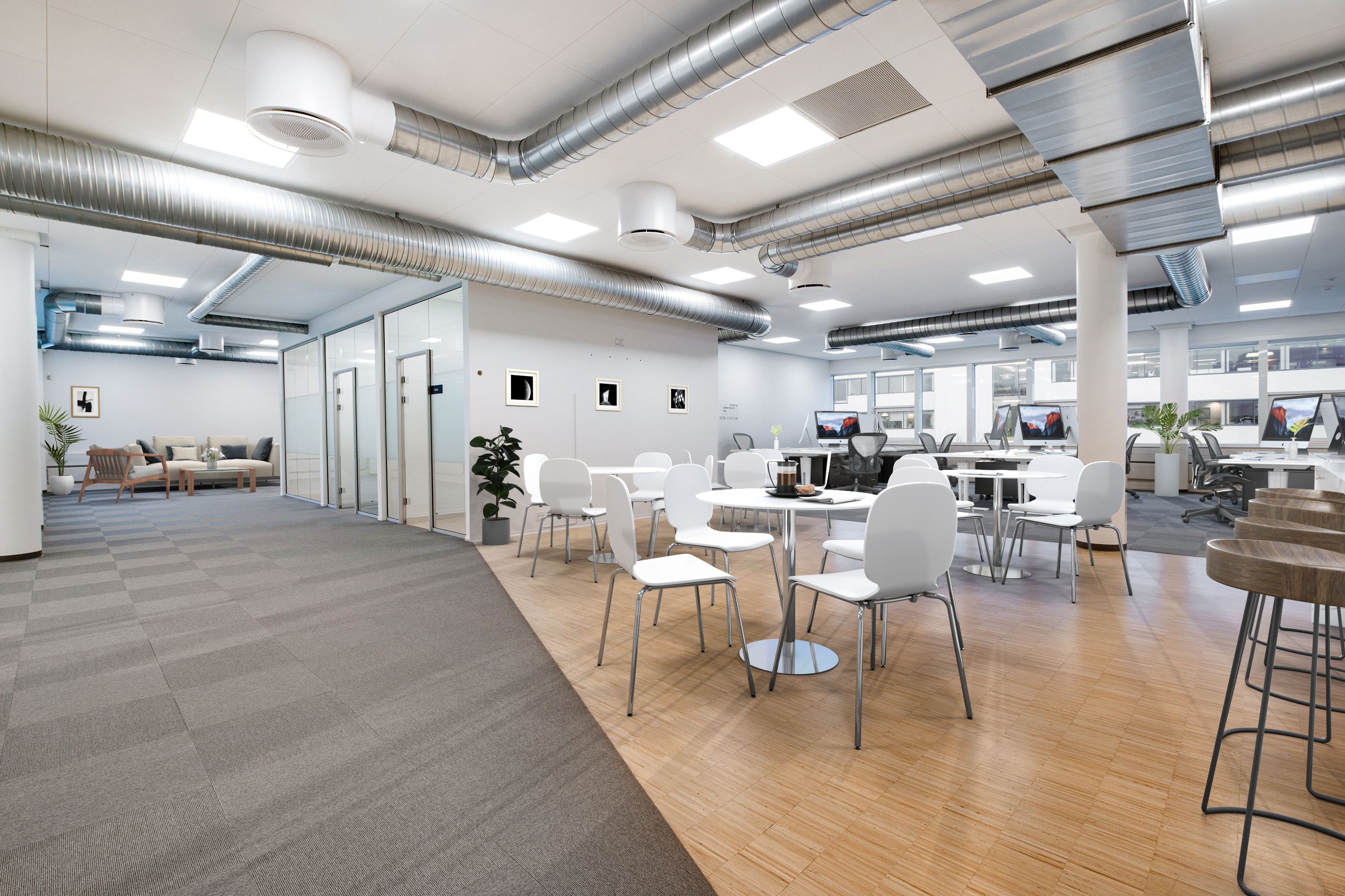 Moderne kontor med trægulve, hvide borde og stole, plante og computere