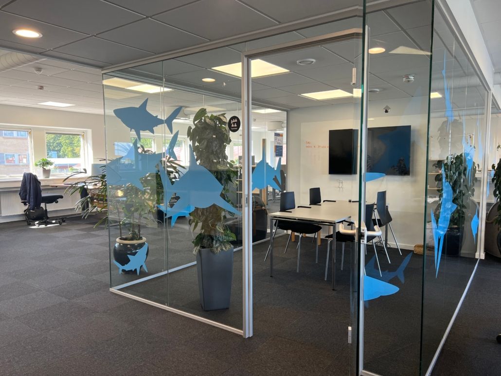 Voksværkets kontor i Aarhus med hajer i glas og tv-skærme på væggen
