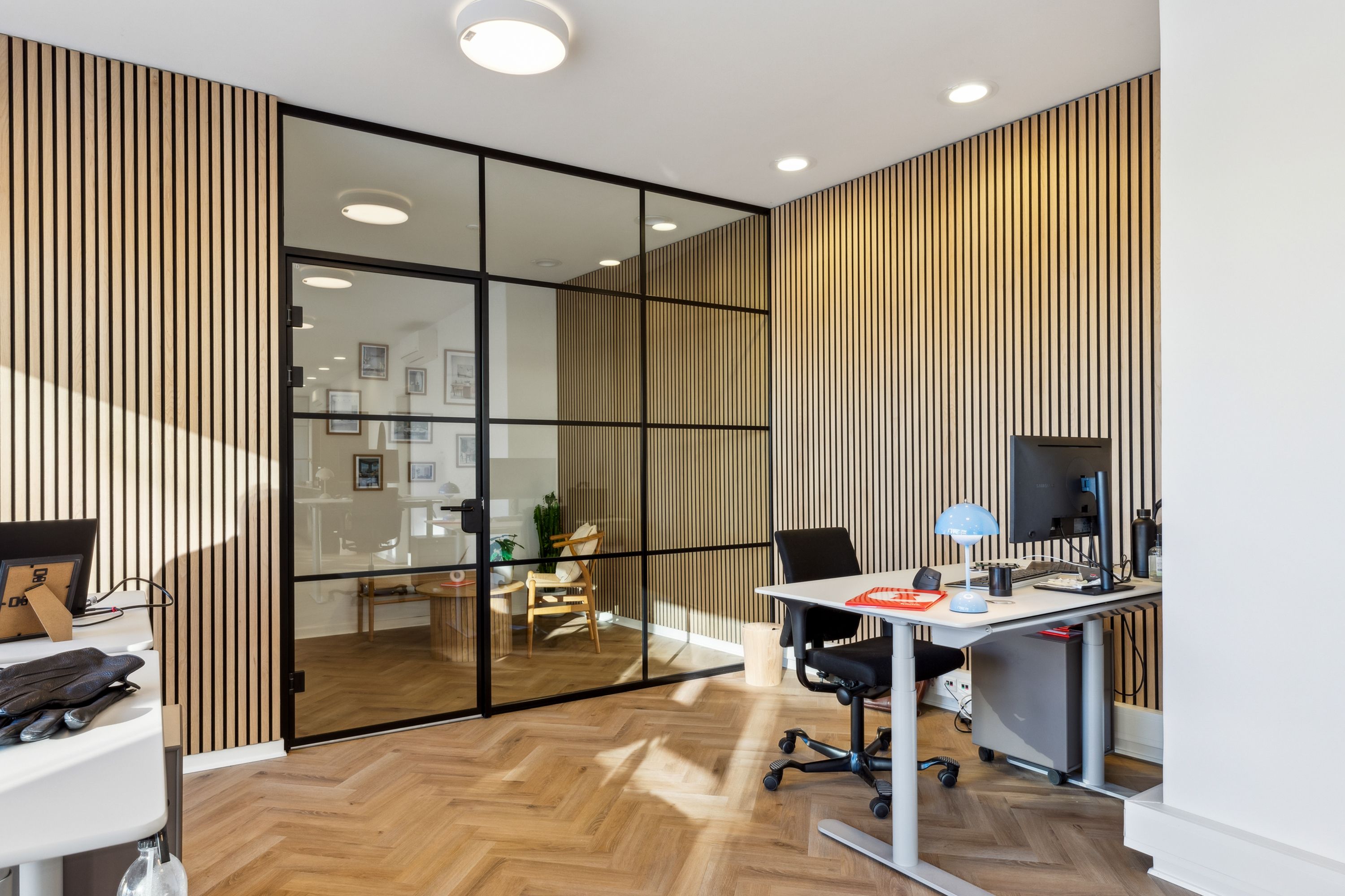 Kontorrum med moderne design, højloft, lysekroner, trægulve, højstole, skrivebord, computer, lamper, fototapet og lyse