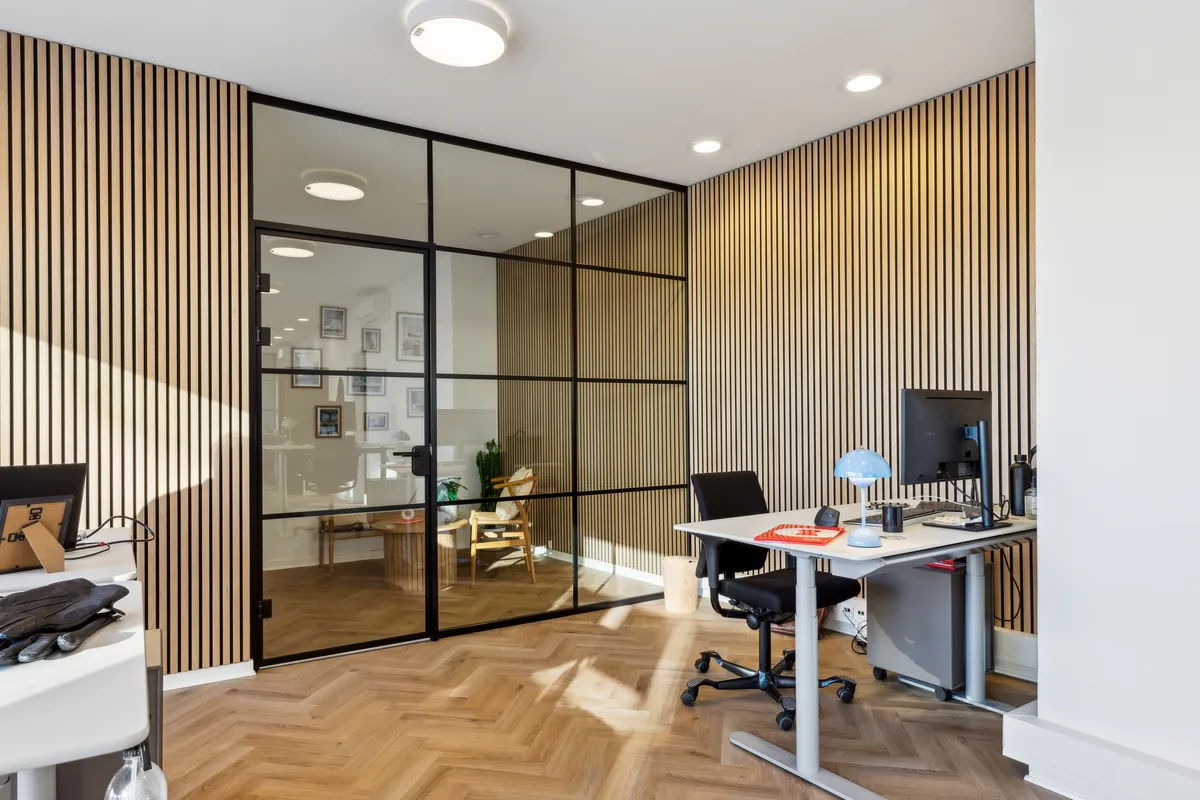 Kontorrum med moderne design, højloft, lysekroner, trægulve, højstole, skrivebord, computer, lamper, fototapet og lyse