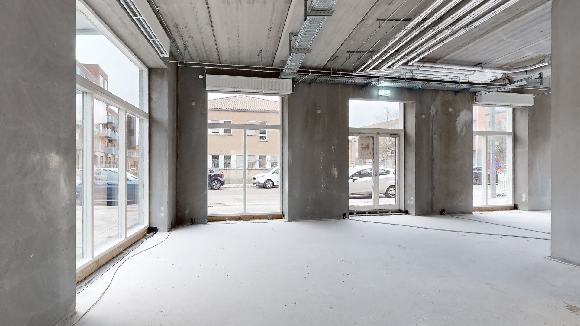 Forretningslokaler med store vinduer og moderne interiør, der egner sig til detailhandel, restaurantion eller café