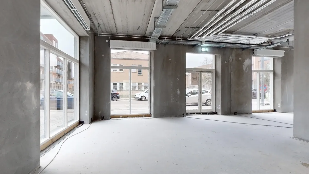 Forretningslokaler med store vinduer og moderne interiør, der egner sig til detailhandel, restaurantion eller café