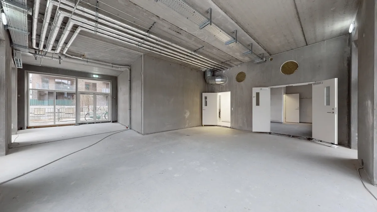 Tomt lokale med hvide døre, glasdøre og store vinduer til lys og udsigt til gaden udenfor