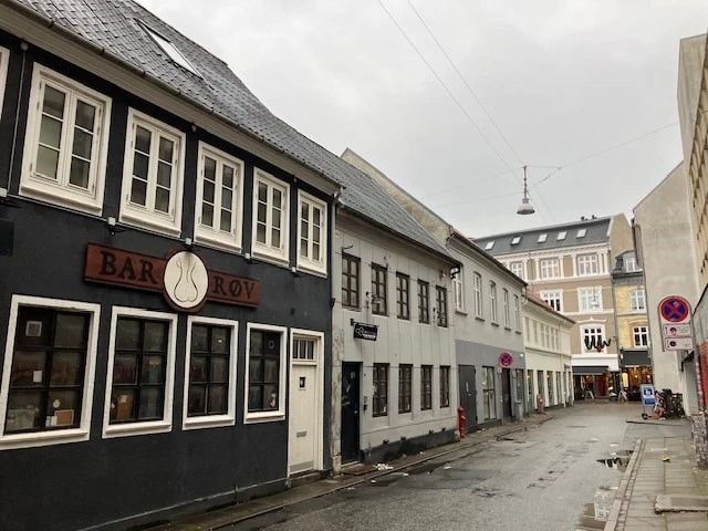 En gammel bygning med teksten Bar Roy og flere vinduerne, der vender ud mod en tom gågade i Aalborg