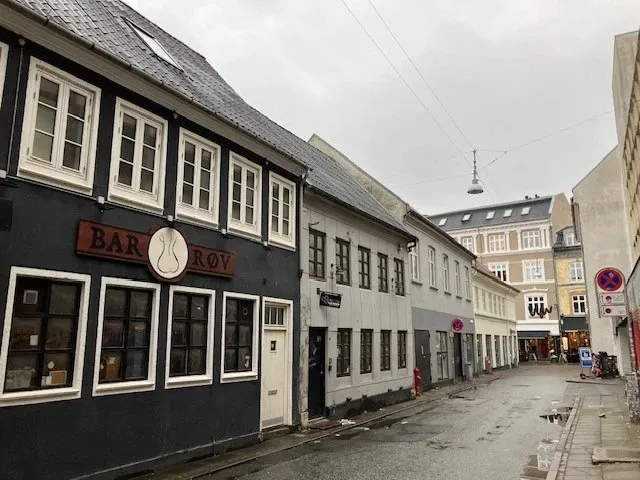 En gammel bygning med teksten Bar Roy og flere vinduerne, der vender ud mod en tom gågade i Aalborg
