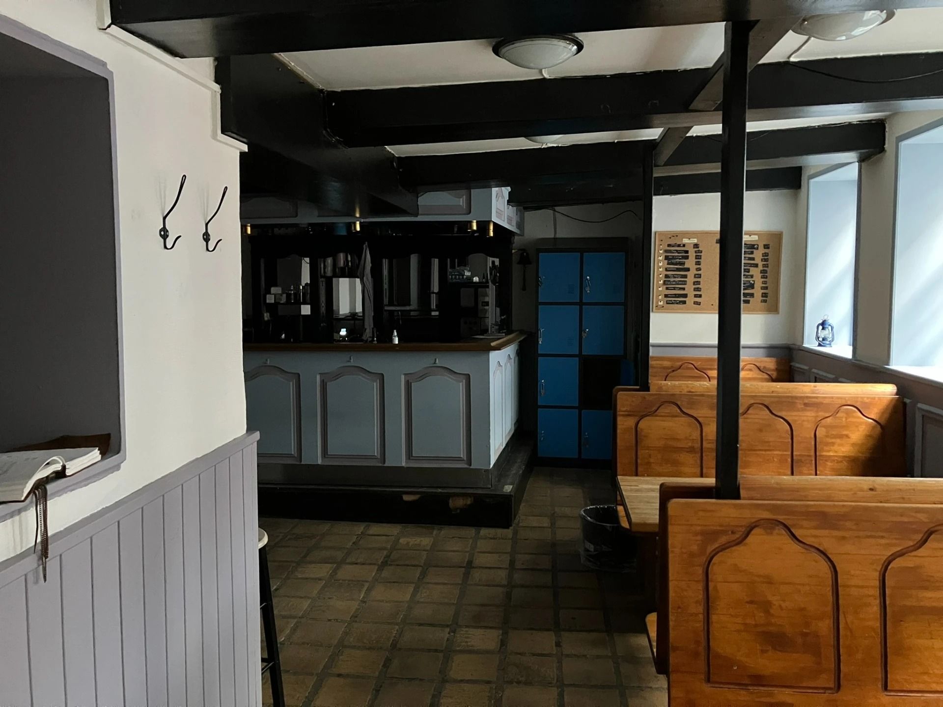 Indvendig i et gammelt bryggeri er der en bar, der vender mod en gruppe bænke og en lysekron i loftet