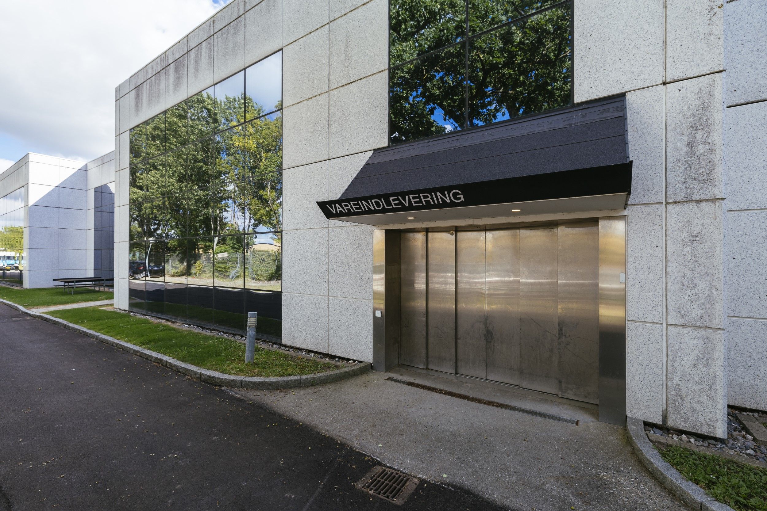 Lejemål med vareelevator og et moderne, minimalistisk design med en stor vareelevator og en indhegnet grund med grønne anlæg