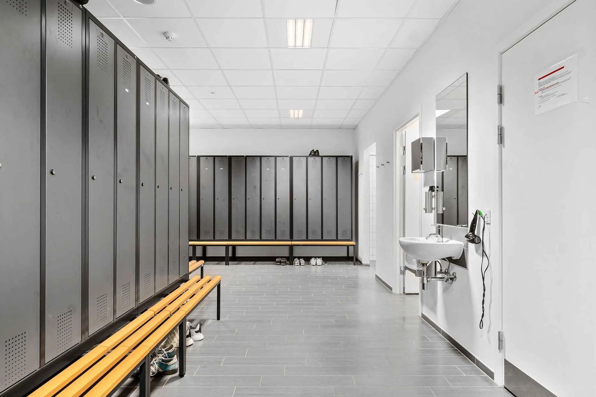 Højloftet og funktionelt indrettet garderobe med lyse loftsbelægninger og spejle i hvide vægge