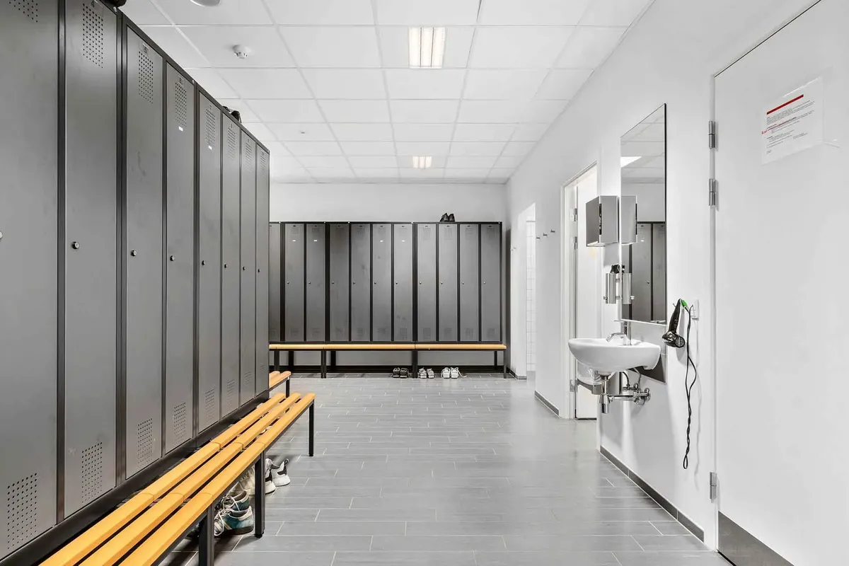 Højloftet og funktionelt indrettet garderobe med lyse loftsbelægninger og spejle i hvide vægge