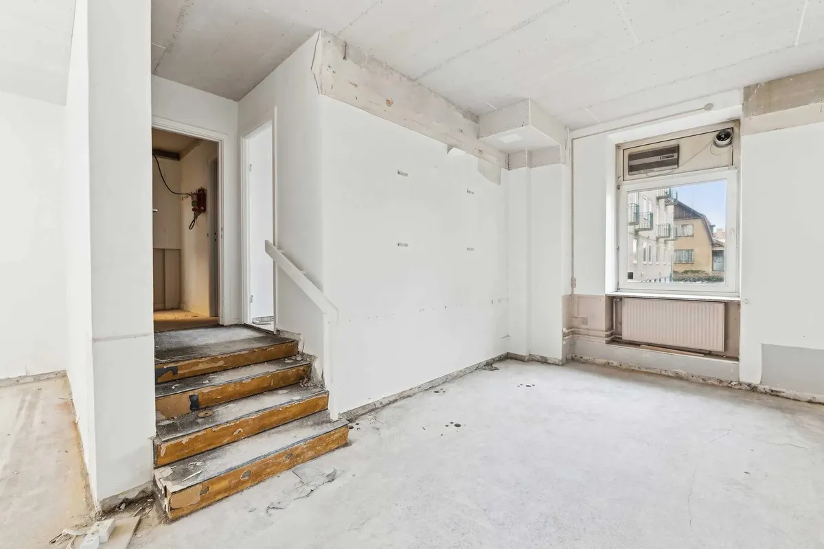 Rummeligt og renoveringsvenligt salgslokale med stige og vindue til gården