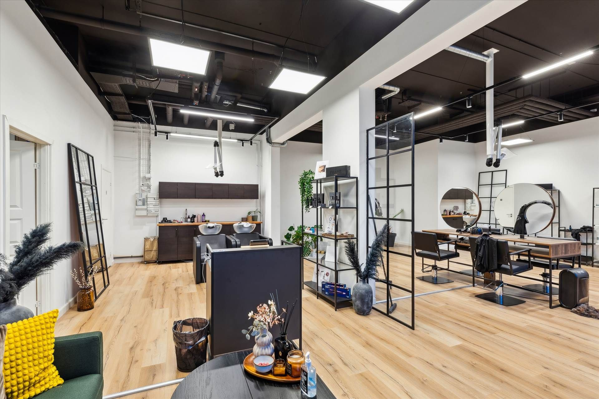 Salon med hårstyling og skønhedspleje, moderne design med lyse lofter, trægulv og højkvalitets udstyr, klienter får