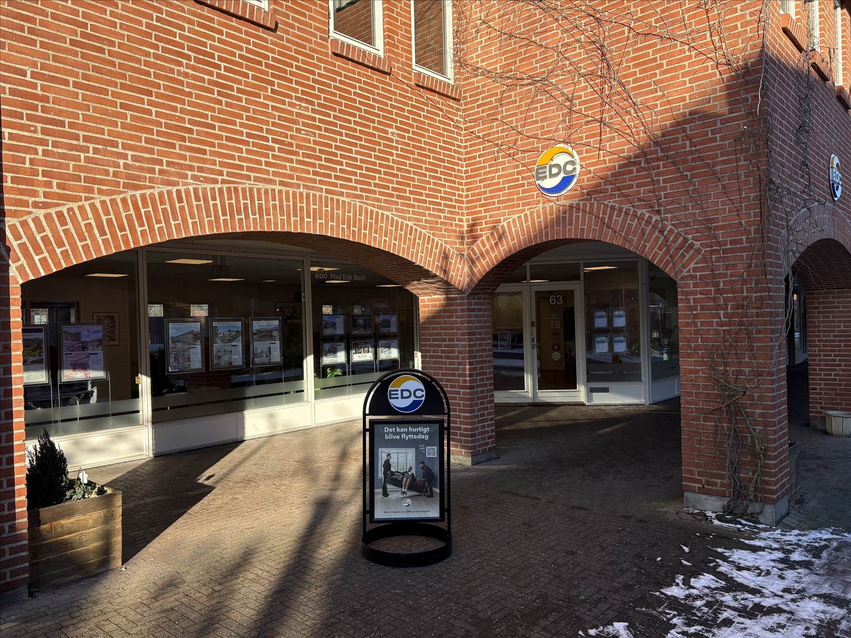Kontorbygning i Solrød med vinduer og indgang med teksten EDC. På forsiden står der et skjold med teksten EDC og logoet. Der