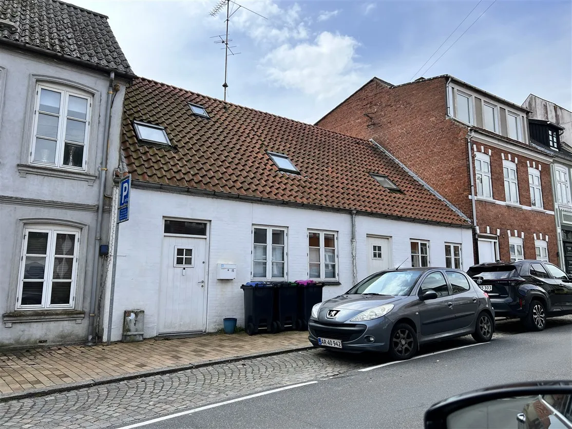 Afkast 6,20% DK-Estate viser en smuk hvid bygning med mange vinduer og en rødt tegltag