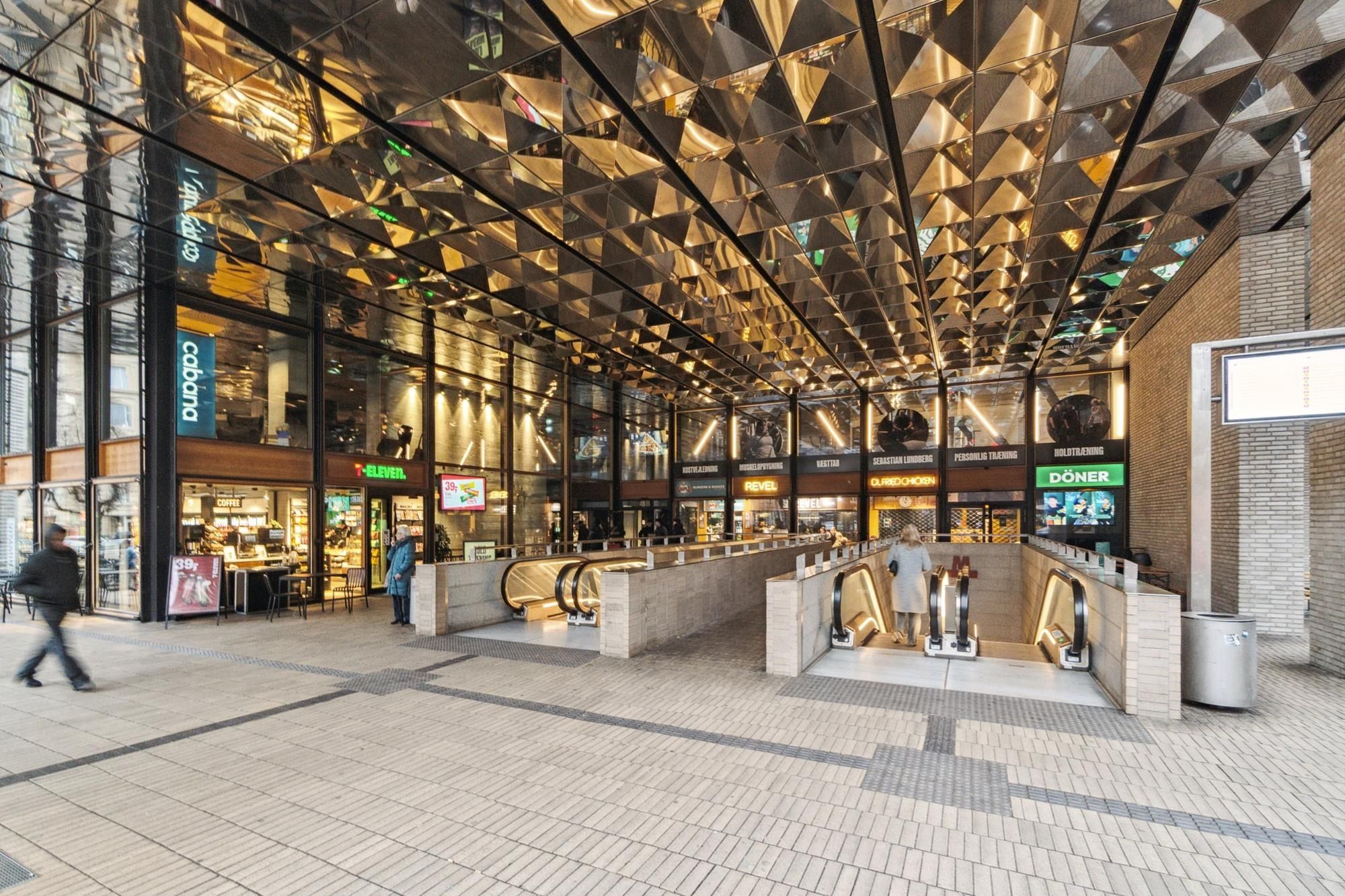 Forretningslokaler med varemærker, mennesker, opgang og gulv med gul og grå teglstensflis, vinduer, reb og skilte med navne