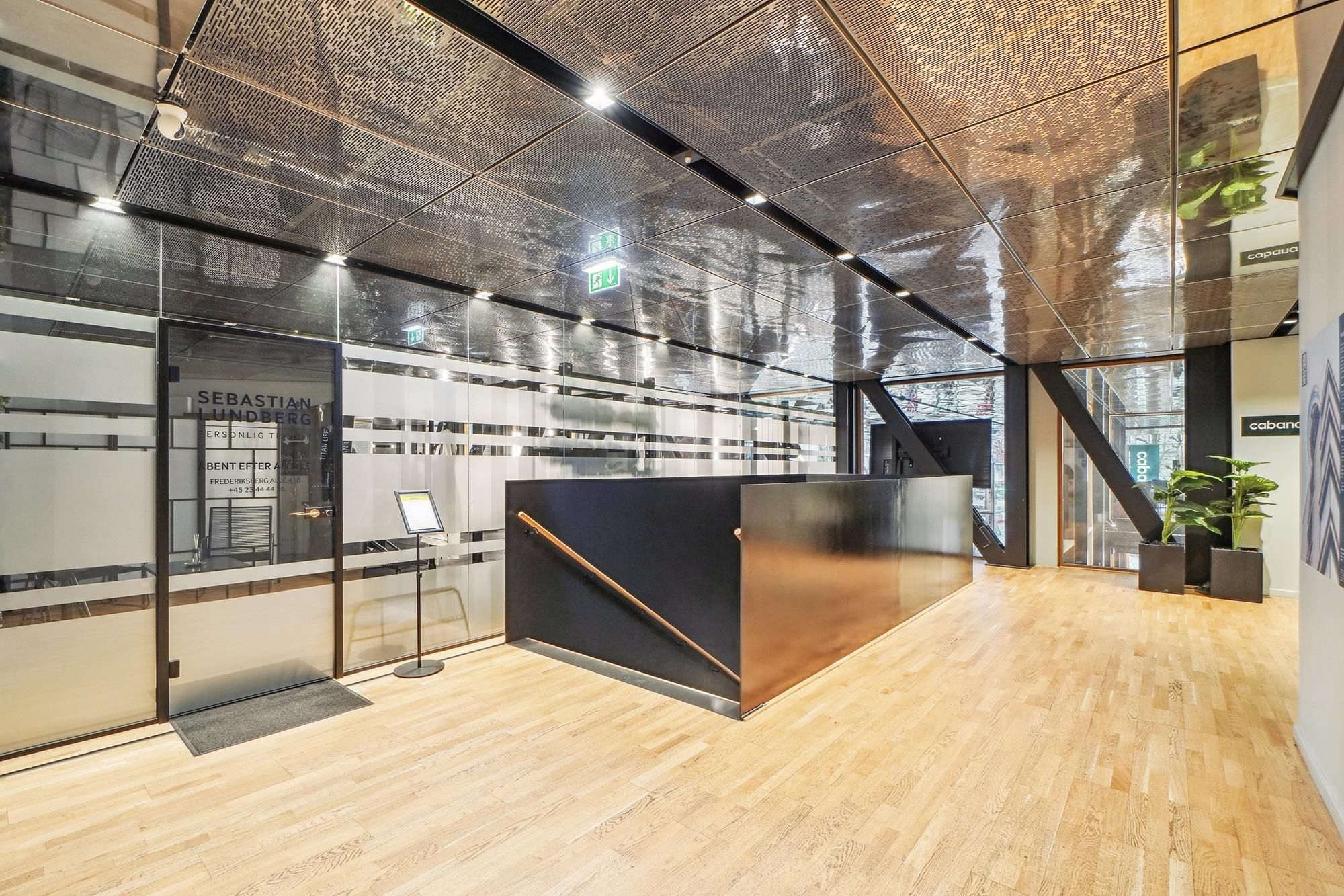 Modernt lobby med møbelkomponenter, gulvbelægning og plantepots. Annoncerecept med navnet Sebastian Lundberg. Møbler og