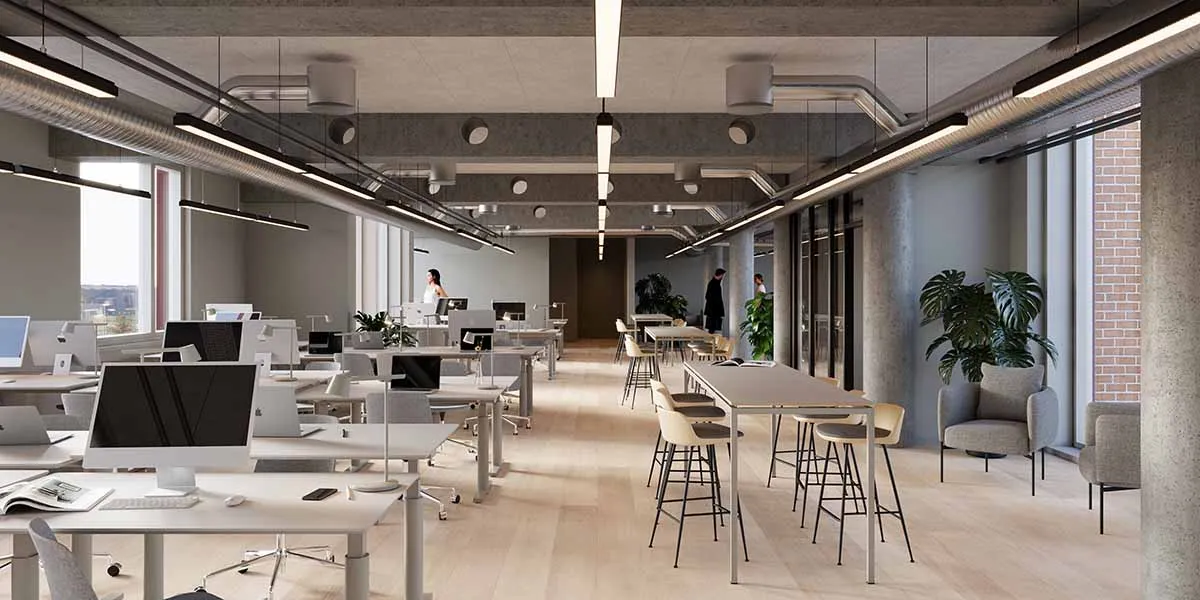 En moderne kontor med høje lofter, lysegule vægge, lysekroner, en stor gulvvasket plante og to kvinder, der går i baggrunden