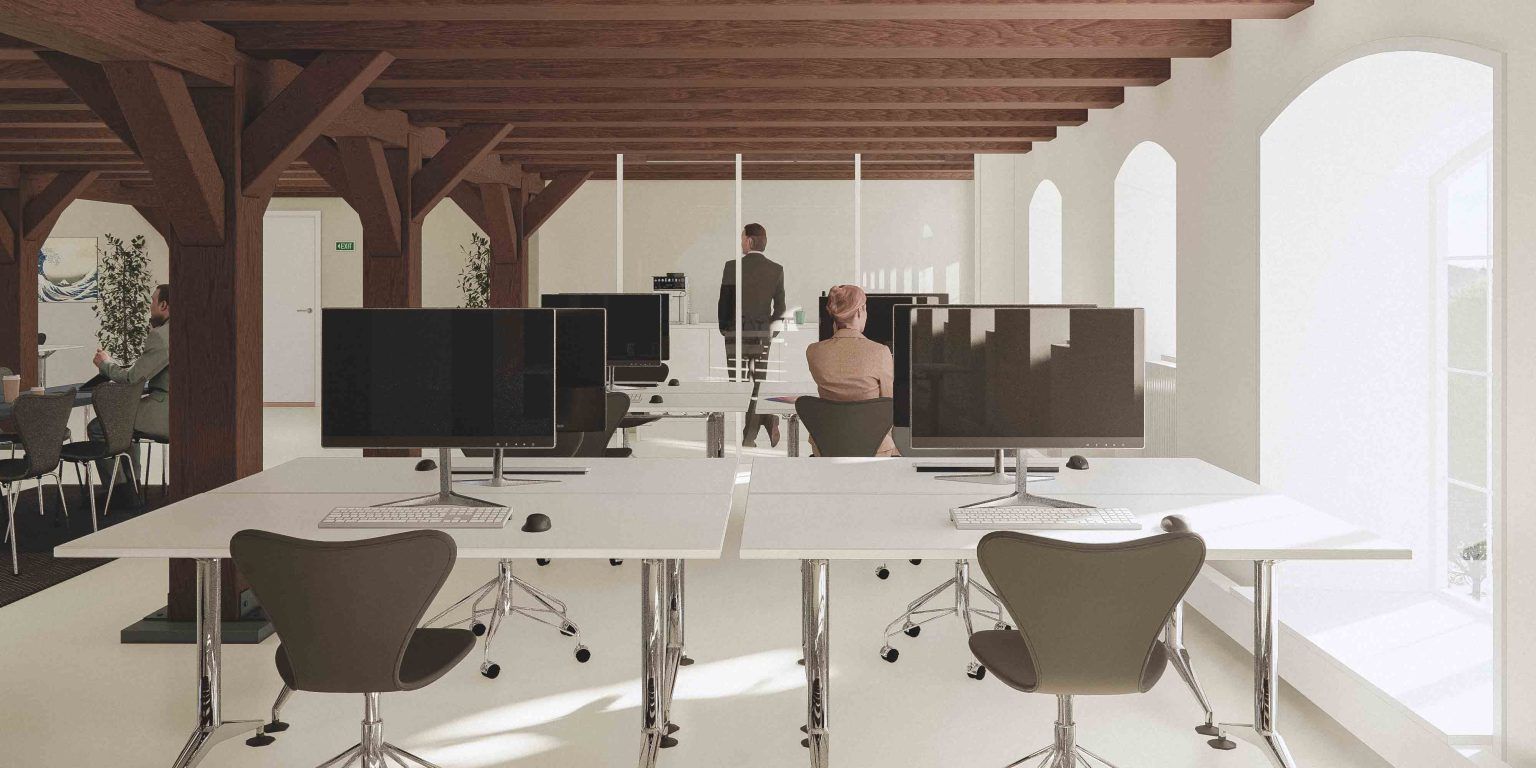 Et moderne kontor med højt til loftet og lyse gulve, to skriveborde med computere og en person i bukser og en skjorte