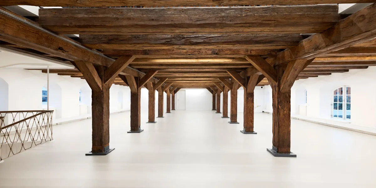 Det gamle pakhus indeholder en stor hal med træbjælker og hvide vægge og gulv samt et højt loft