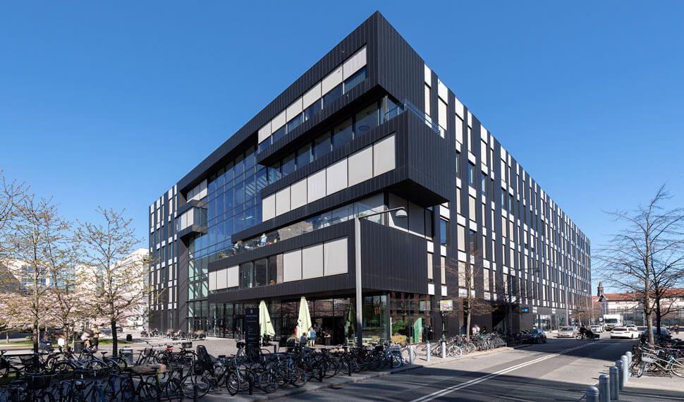 Moderne bygning med en facade af sort og hvide stålpaneler og store vinduer