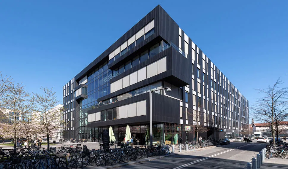 Moderne bygning med en facade af sort og hvide stålpaneler og store vinduer