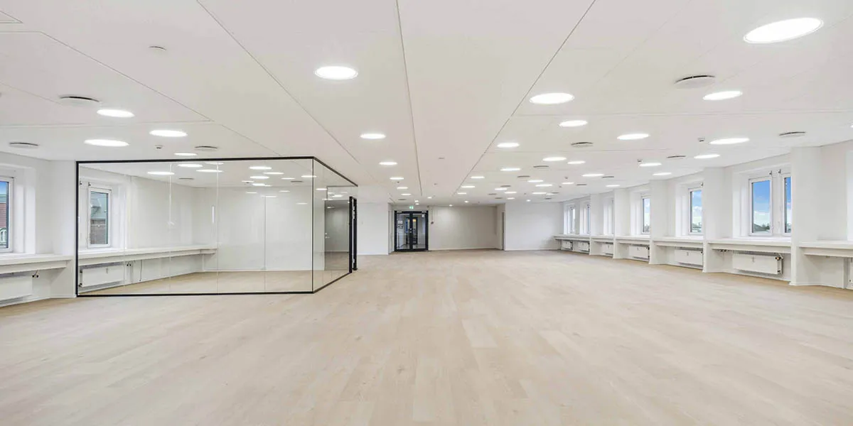 Tomt og pænt kontor med lyse gulve og store vinduer til meget lys og gode arbejdsforhold