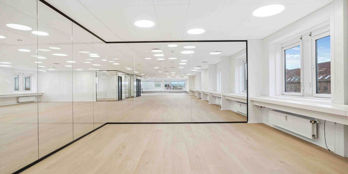 Luksuriøs kontorlokal med blanke spejlvægge og højloftede rum med lyse og funktionelle møbler og lysekroner