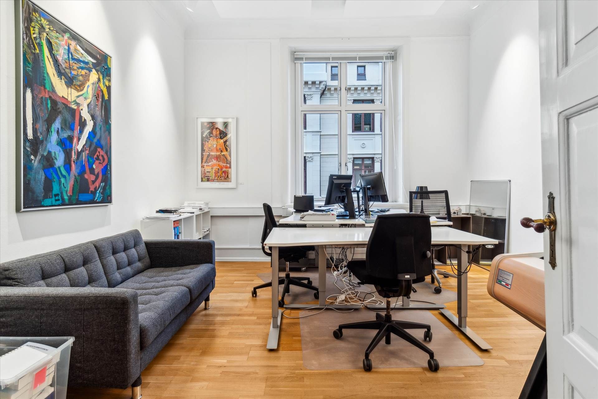 Herskabeligt kontor med højloftede rum og lyse vinduer, smukke loftsbjælker og trægulv. Kontoret er møbleret med skriveborde