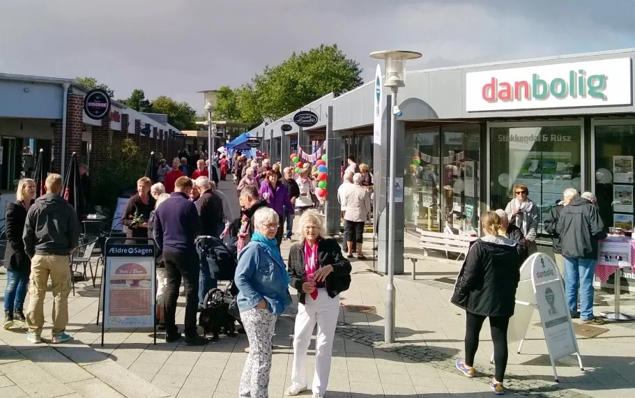 Mennesker går i gågaden foran Dan Bolig og snakker med hinanden og nyder sammenværet