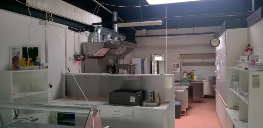 Køkken med røgloft, spisestue, hvide hylder, skabe, børnefigurer, ure og glas. Køkken med ovn, brønd, vaskemaskine og