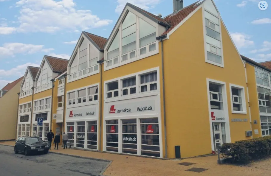 Lyst kontor i Aabenraa med mange vinduer og tre personer foran døren