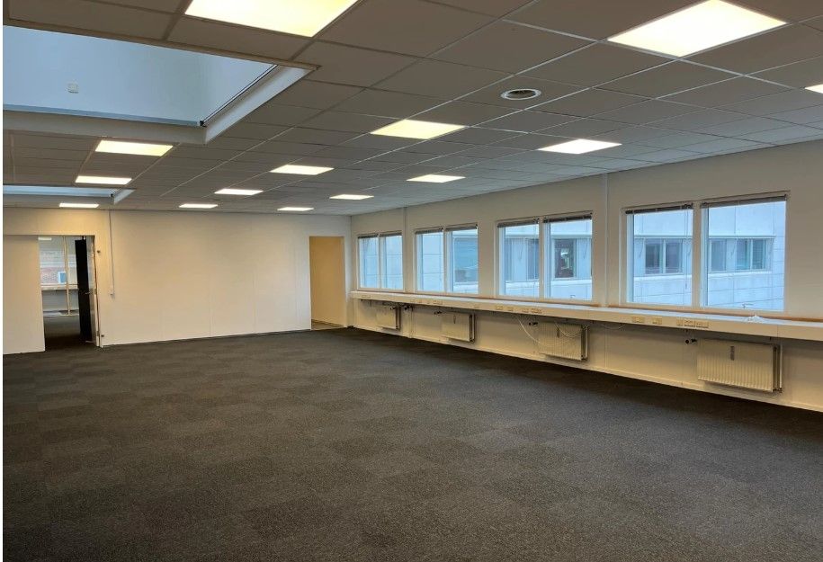 Lyst og rummeligt kontorlokale med vinduer, lysekroner og lysegulv i Viby J.