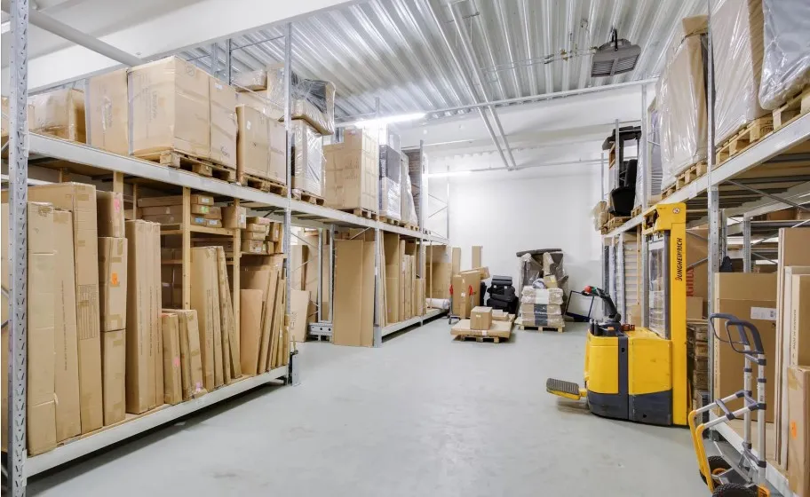 Lager med store mængder kartoner og emballagematerialer. Forskellige størrelser og farver samt emballageredskaber og et