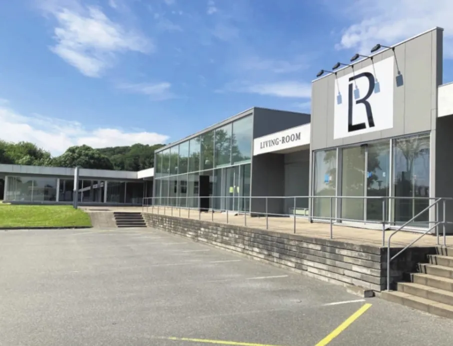 Store, moderne forretningslokaler med glasfassade og parkeringsplads i Aabenraa. Steder med oplysningen Living Room og R på