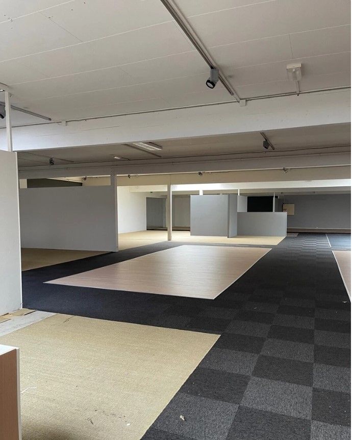 Store, tommede lokaler med store gulve og tæppegulv i hjørnerne. Et stort, lyst gulv i midten af lokalerne.