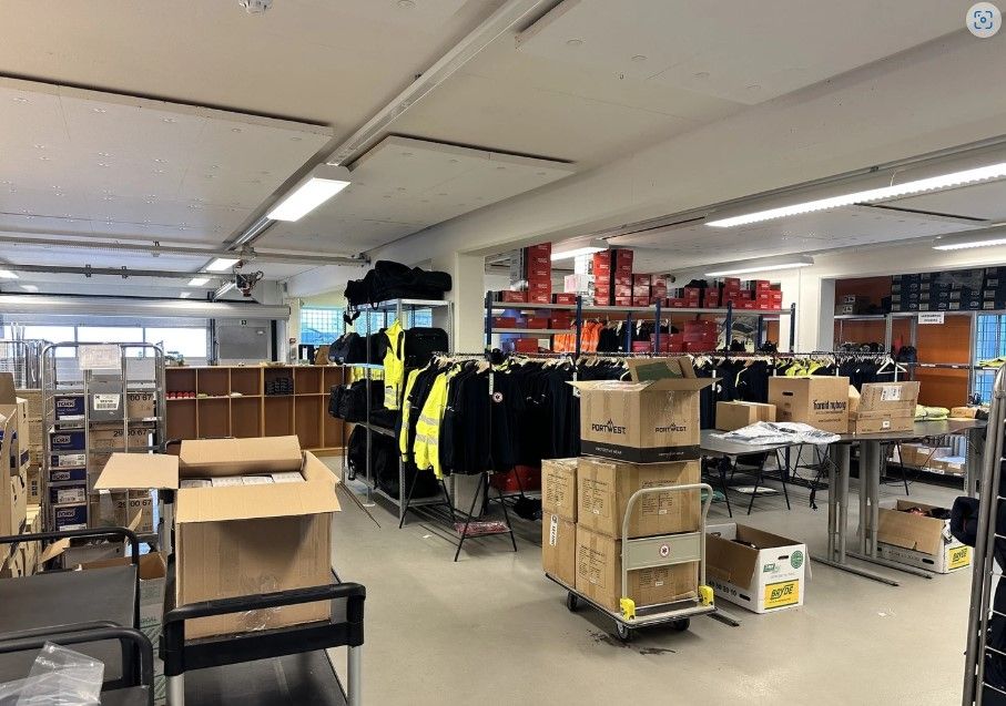 Fabrik med 384 kvm. Plads i Ballerup. Her er lagerhylder med tøj og sko samt flere kasser og paller.