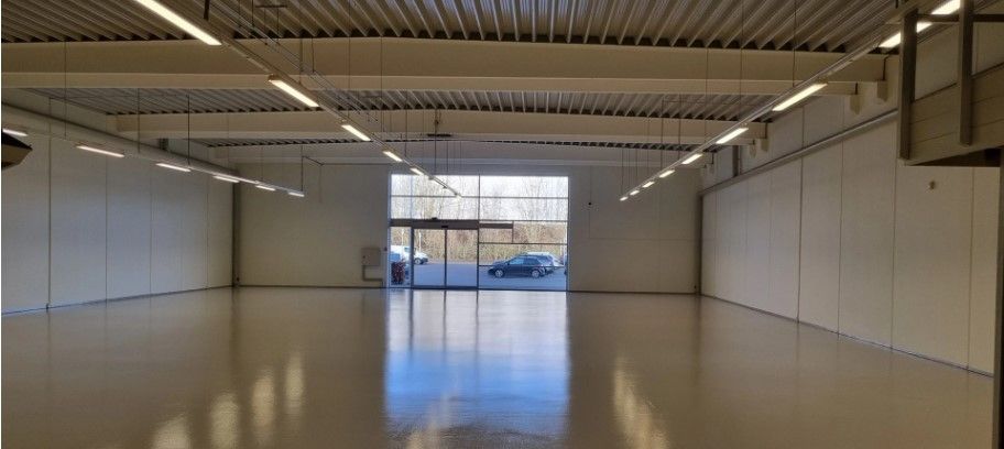 Lokale med højloft, hvide vægge, glasdøre og vinduer, samt lysekroner. Lejemålet kan bruges til forretningsformål, herunder