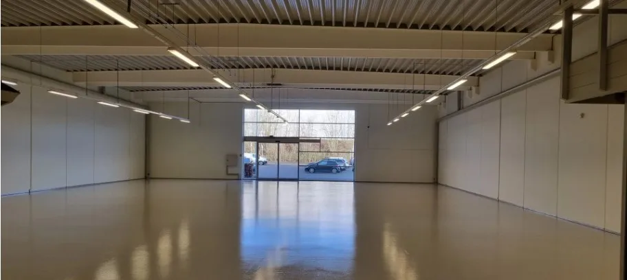 Lokale med højloft, hvide vægge, glasdøre og vinduer, samt lysekroner. Lejemålet kan bruges til forretningsformål, herunder