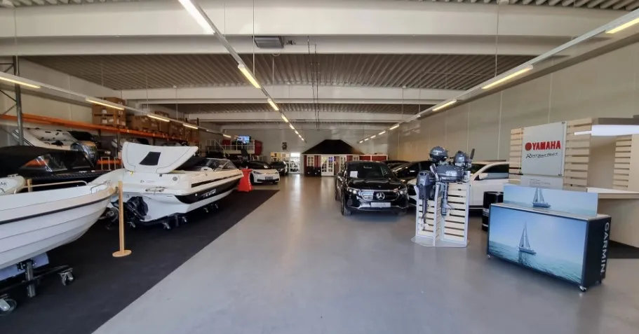 Bilforretning med biler, både og andre køretøjer. Yamaha-produkter og skilte med mærkenavnet.