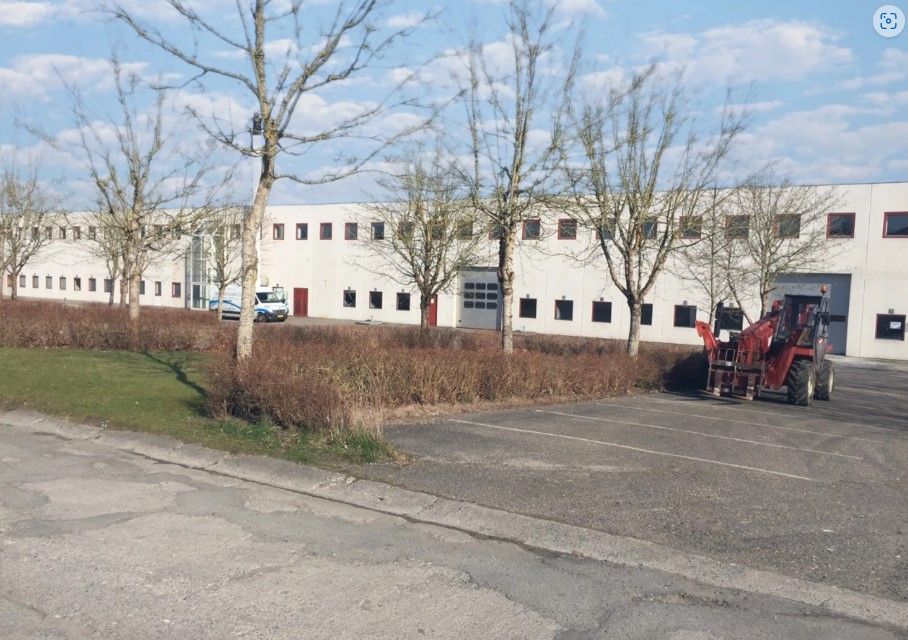 Lagerhal med røde døre og parkeringsplads foran. Der er to sammenhængende lagerhaller på hver 2.500 m2 med 6-7 meters