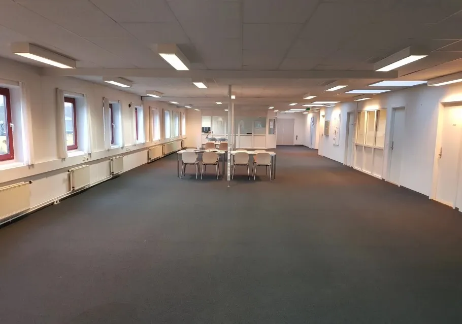 Store lagerhaller med lysegul gulvbelægning og hvide vægge samt samme farve på loftet med indbygget belysning.