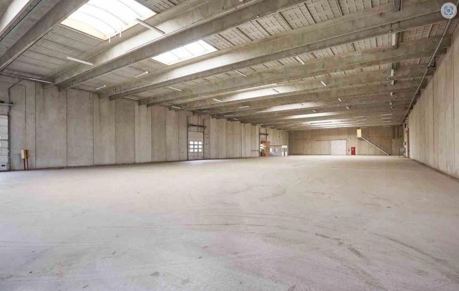 Lager med kontor med lyse skifergulv og høje lofter med mange lyskrydsere og vinduer