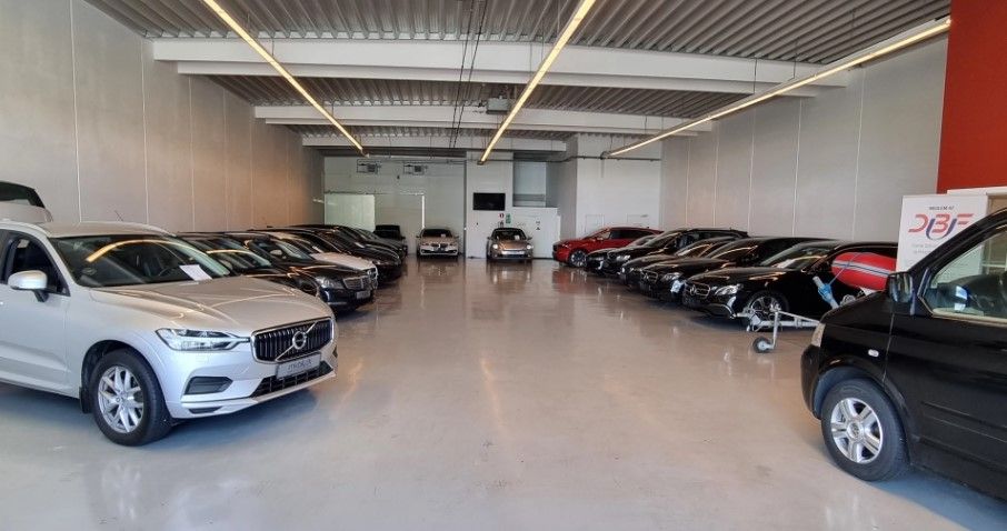 Butikken med nye biler og SUVer er i en stor, vellyst lokal. Mange biler er parkeret i rækker og tæt på hinanden.