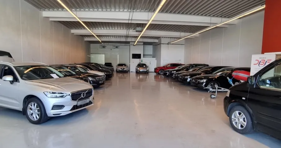 Butikken med nye biler og SUVer er i en stor, vellyst lokal. Mange biler er parkeret i rækker og tæt på hinanden.