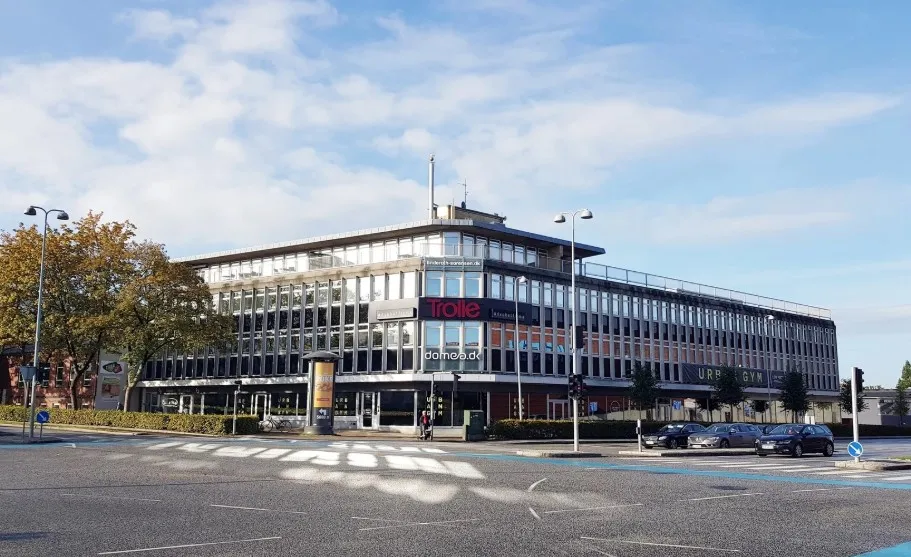 Vejle er hovedbyen i Vejle Kommune. På Sønderbrogade 36 er der et kontorbyggeri med butikker og parkeringsplads.