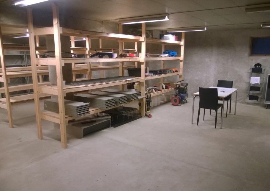 Lejlighedsvist rum med masser af plads til opbevaring af diverse ting, såsom materialer, værktøj og andet. Et bord og stole