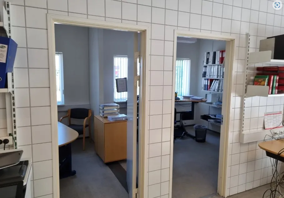 Kontorlokale med to separate rum, skriveborde, stol, skrivebordsstativ, computer, skab, ståpulte, papirkurv og