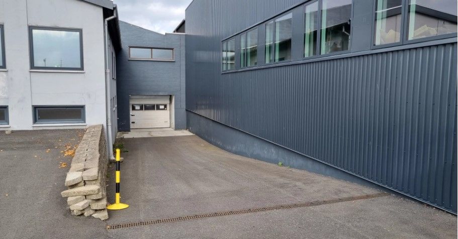 To huse med store vinduer og garagedør, samt gul bollard for at markere adgangsvej i Horsens.