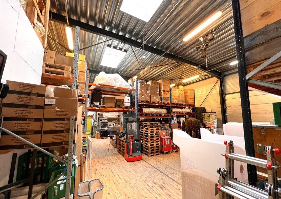 Lager med lagerhylder og kasserne samt ekspeditiv vogn og pallehylderne med palle og kasser