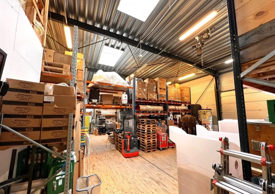 Lager med lagerhylder og kasserne samt ekspeditiv vogn og pallehylderne med palle og kasser